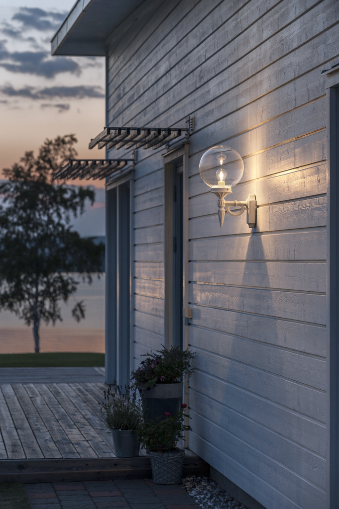 Orion Vit utelampa från Konstsmide - Med sina dekorativa detaljer och tidl&ouml;sa stil blir denna v&auml;gglampa en elegant detalj som lyfter din fasad och skapar en inbjudande atmosf&auml;r.