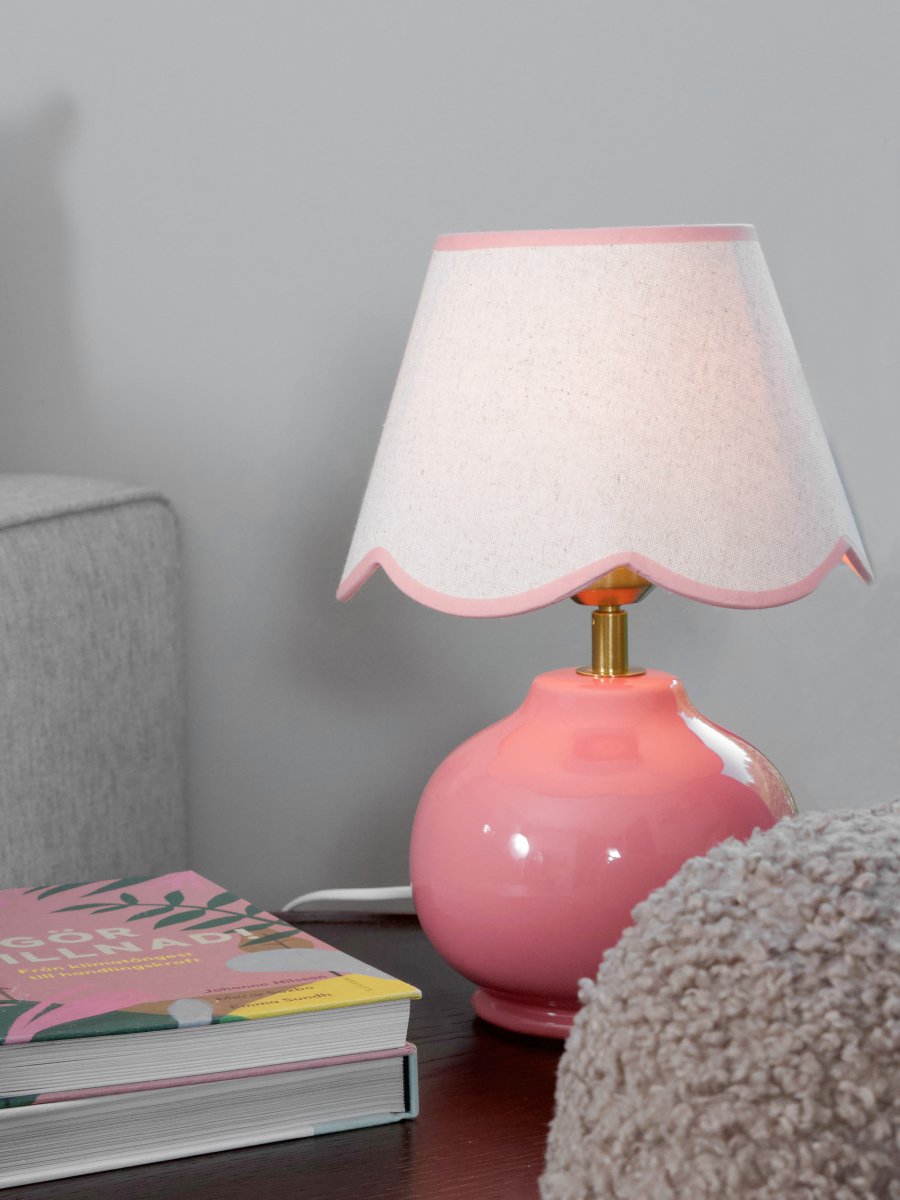 Nell 34cm Rosa bordslampa från PR Home - Den klotformade lampfoten i blank, rosa f&auml;rg kombineras med en beige lampsk&auml;rm av textil som ger ett mjukt och harmoniskt uttryck, perfekt f&ouml;r b&aring;de sovrum och vardagsrum.