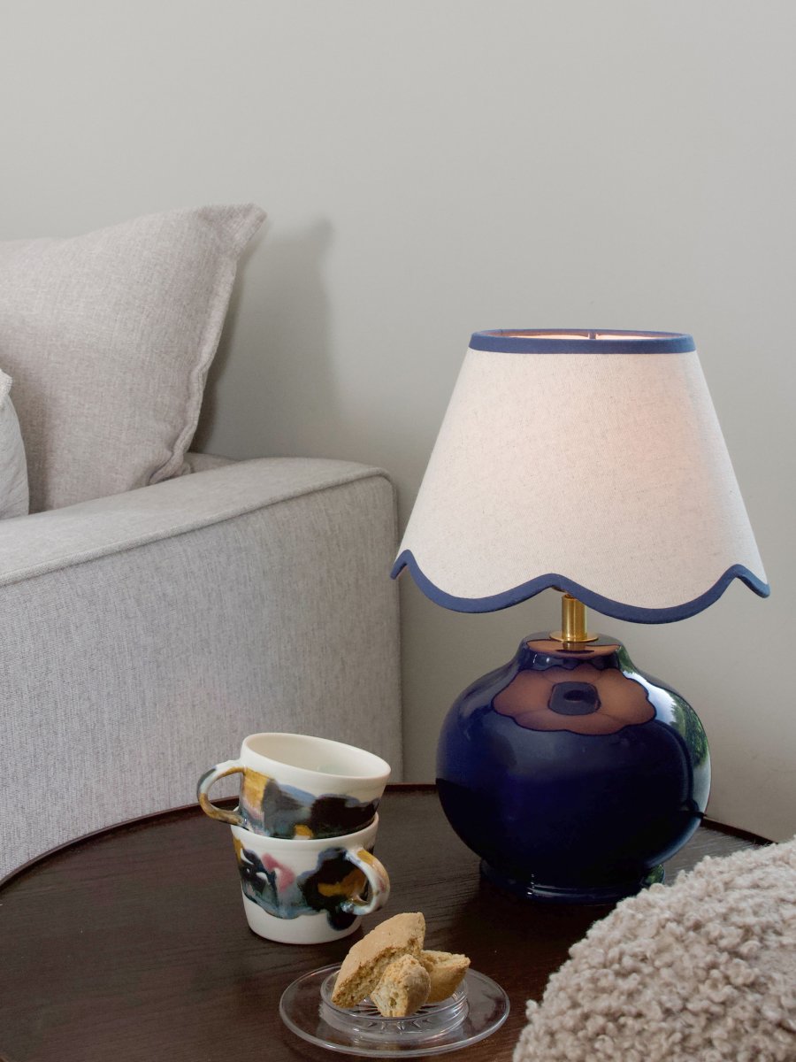 Nell 34cm Blå bordslampa från PR Home - Den klotformade lampfoten i blank, djupbl&aring; f&auml;rg kombineras med en beige lampsk&auml;rm av textil som ger ett mjukt och harmoniskt uttryck, perfekt f&ouml;r b&aring;de sovrum och vardagsrum.