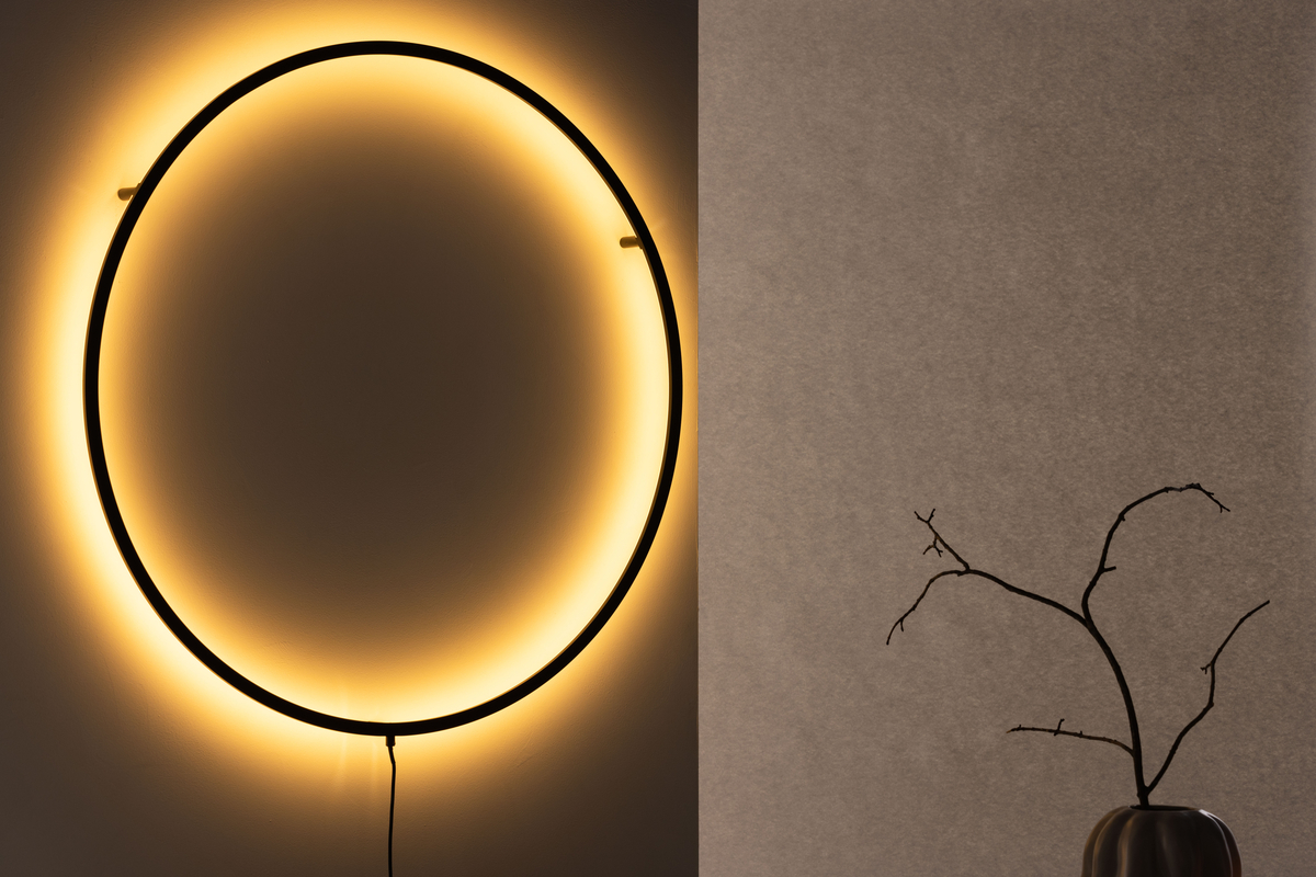 Sörmjöle Svart vägglampa från Venture Design - Lampan har en rund ram i svart aluminium med led-lampor bakom som ger ett vackert ljus p&aring; v&auml;ggen och ett behagligt sken i rummet.
