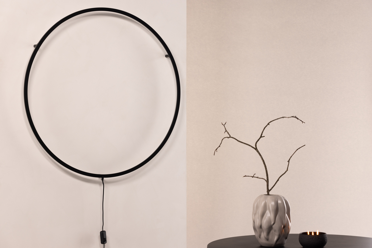 Sörmjöle Svart vägglampa från Venture Design - Lampan har en rund ram i svart aluminium med led-lampor bakom som ger ett vackert ljus p&aring; v&auml;ggen och ett behagligt sken i rummet.