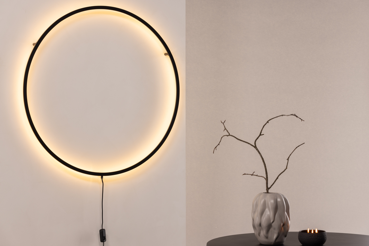 Sörmjöle Svart vägglampa från Venture Design - Lampan har en rund ram i svart aluminium med led-lampor bakom som ger ett vackert ljus p&aring; v&auml;ggen och ett behagligt sken i rummet.