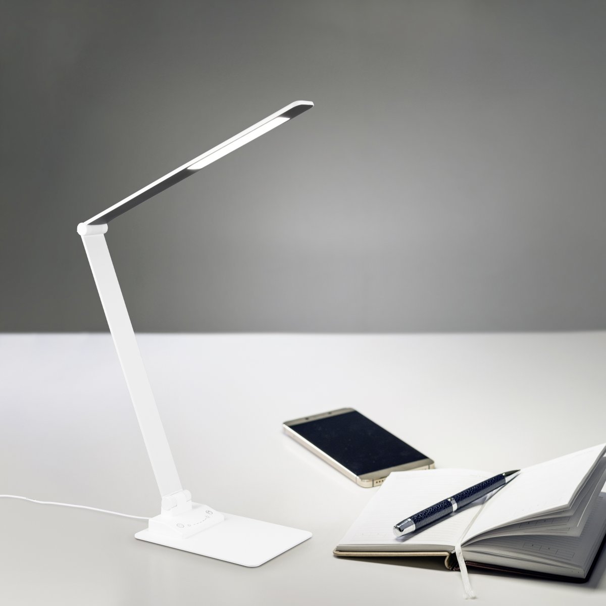Travis 70cm Vit skrivbordslampa från Trio Lighting - De praktiska lederna p&aring; armaturen g&ouml;r det m&ouml;jligt att rikta ljuset individuellt, vilket g&ouml;r armaturen till det perfekta valet f&ouml;r alla arbetsomr&aring;den.