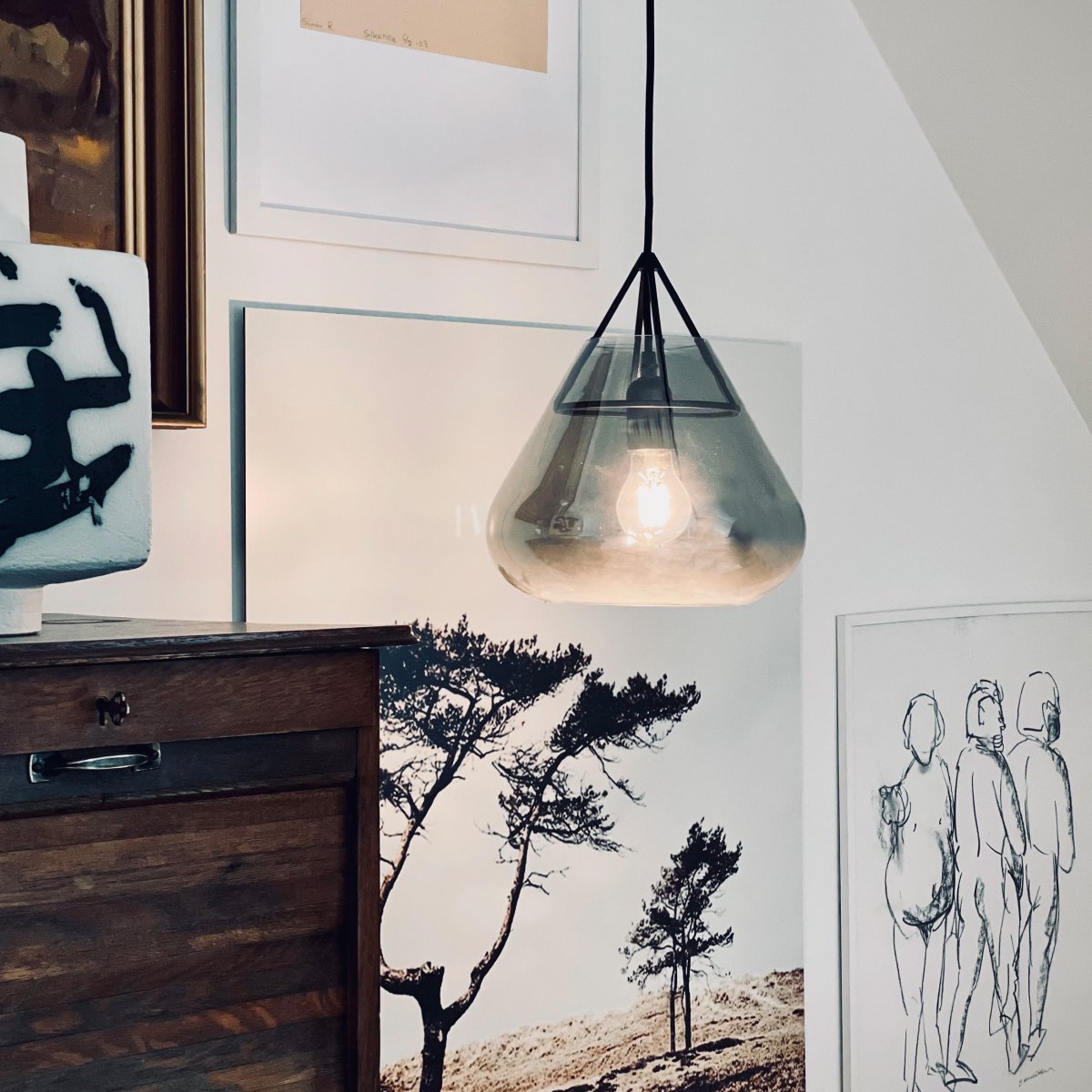 Volta Ø26 Svart taklampa från Dyberg Larsen - Volta pendellampa fr&aring;n Dyberg Larsen kombinerar elegant r&ouml;kf&auml;rgat glas med matt metall f&ouml;r att skapa en pendel som &auml;r lika mycket en designikon som en funktionell ljusk&auml;lla.