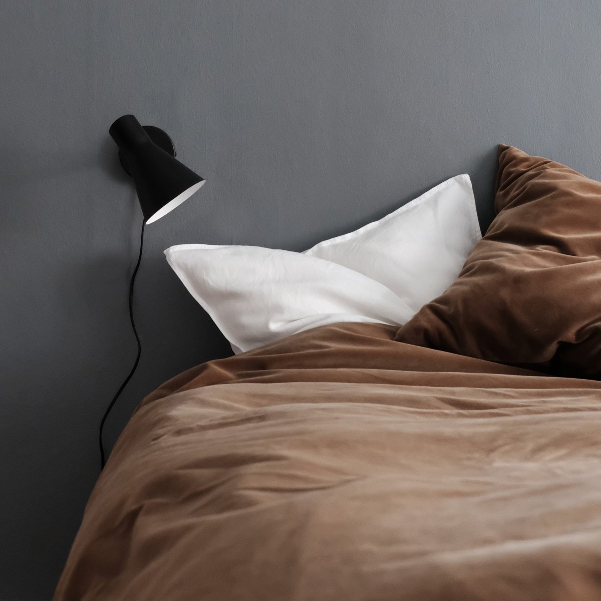 DL12 Svart läslampa från Dyberg Larsen - Med sin moderna, mattsvarta design och vinklade sk&auml;rm ger DL12 ett fokuserat och behagligt ljus, idealiskt f&ouml;r l&auml;sh&ouml;rnor eller som s&auml;nglampa.