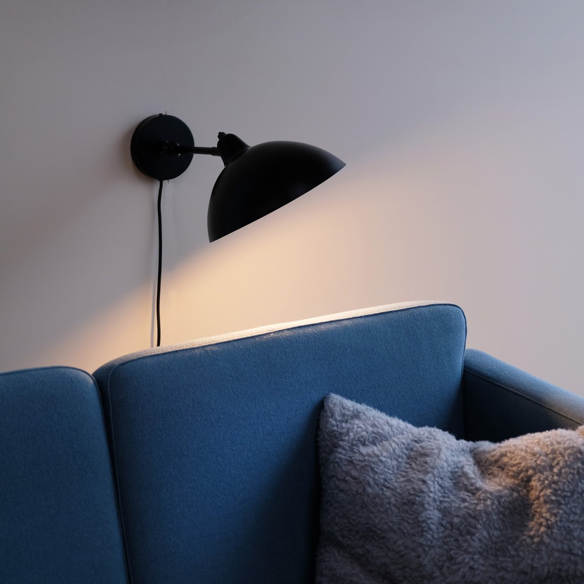 Futura 43cm Svart vägglampa från Dyberg Larsen - Tillverkad i metall med en svart utsida och vit insida, skapar den en minimalistisk look.