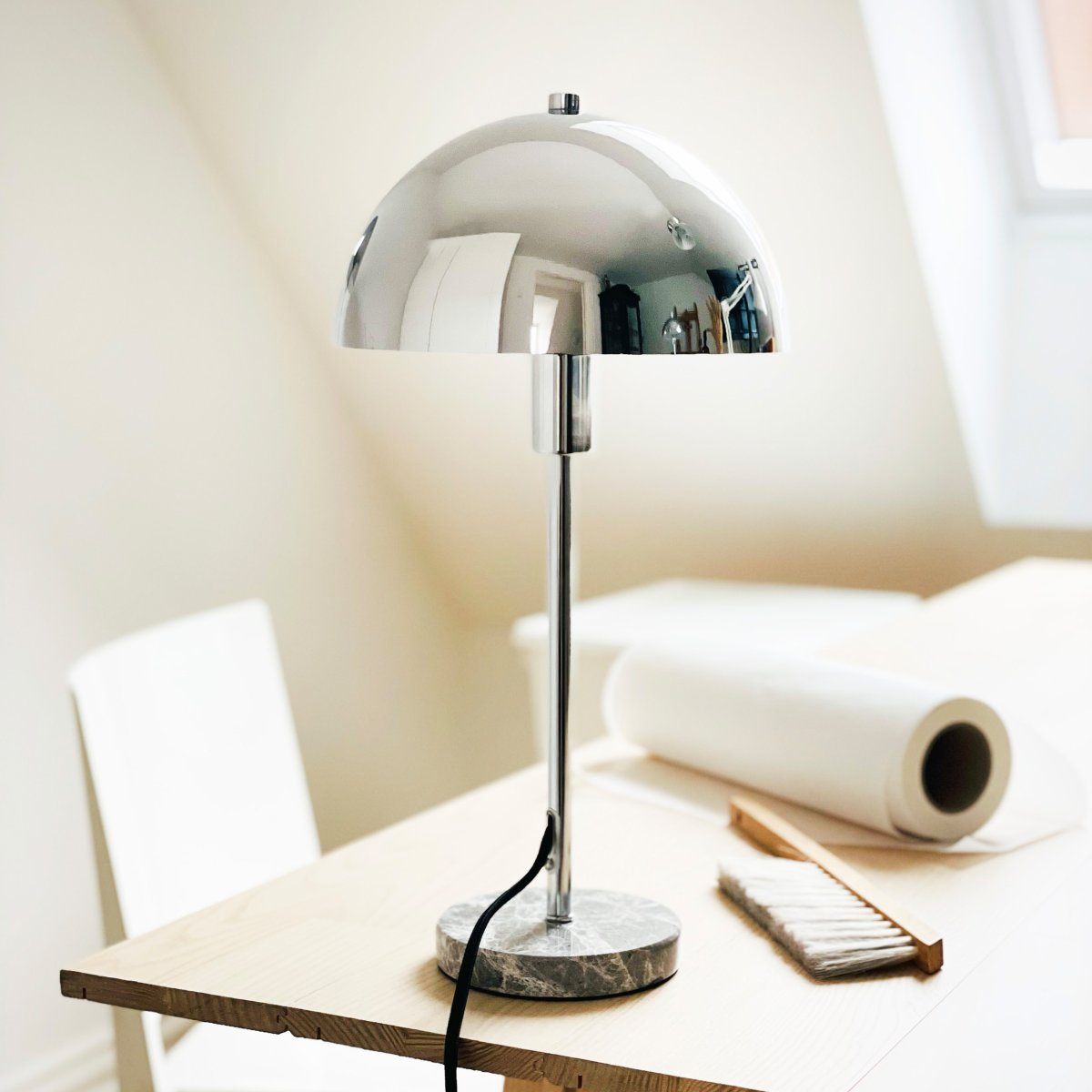 Stockholm 40cm Krom bordslampa från Dyberg Larsen - Den solida marmorfoten ger lampan ett exklusivt och tidl&ouml;st uttryck, medan den smala kromramen tillf&ouml;r en l&auml;tt och stilren k&auml;nsla.