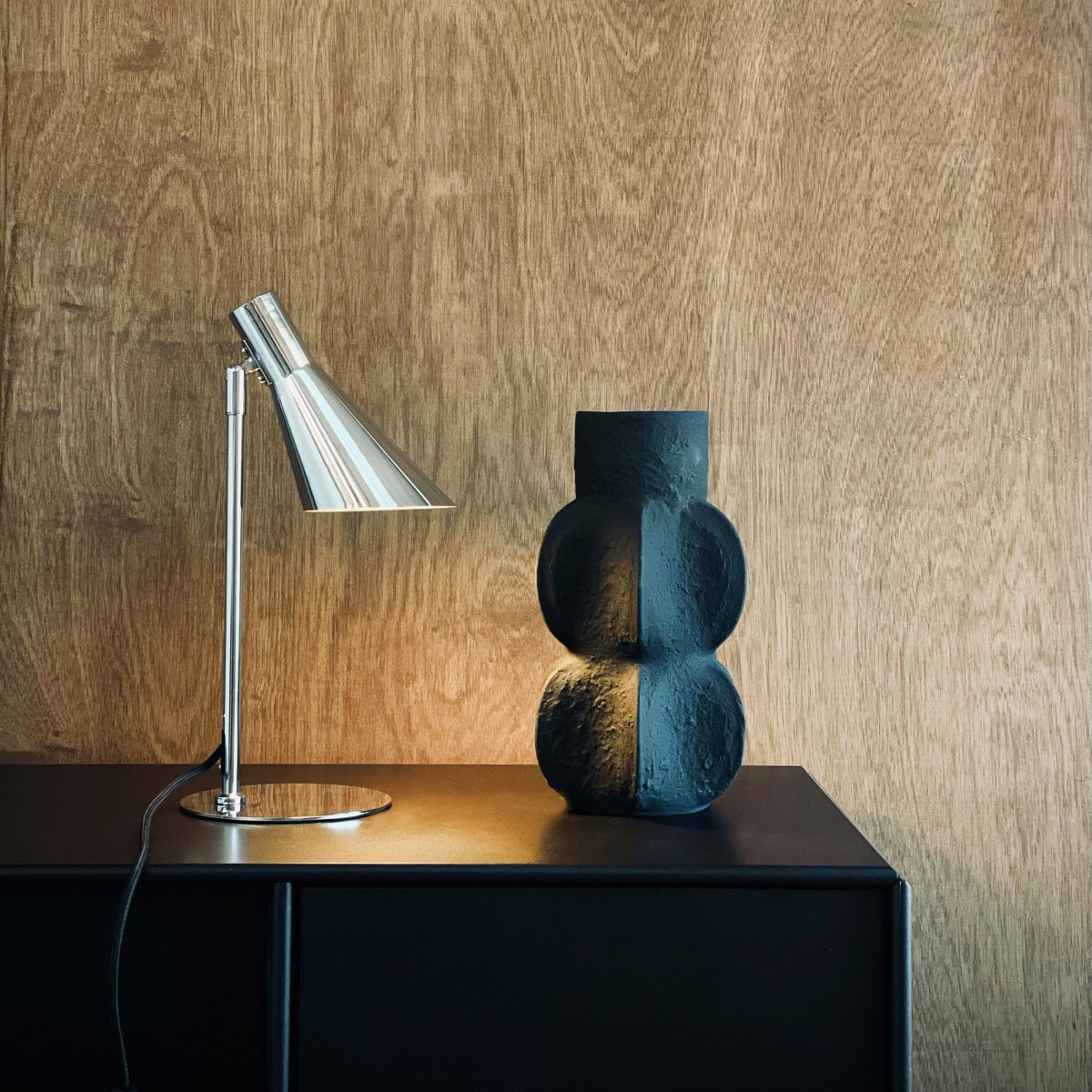 DL12 Mini 40cm Krom skrivbordslampa från Dyberg Larsen - Den &auml;r utrustad med en sk&auml;rm som kan b&aring;de roteras och tiltas, vilket g&ouml;r det enkelt att rikta ljuset efter behov.
