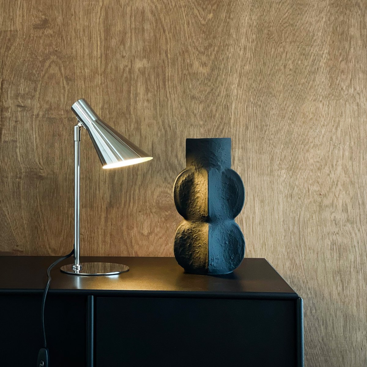 DL12 Mini 40cm Krom skrivbordslampa från Dyberg Larsen - Den &auml;r utrustad med en sk&auml;rm som kan b&aring;de roteras och tiltas, vilket g&ouml;r det enkelt att rikta ljuset efter behov.