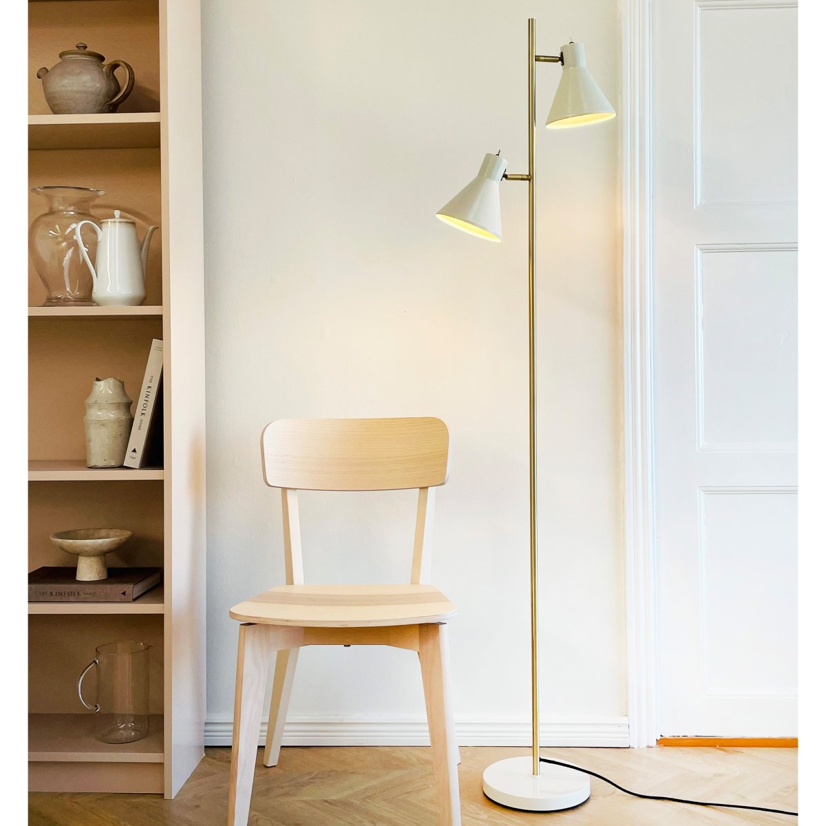 Sleep Shiny vit golvlampa från Dyberg Larsen - Den vita f&auml;rgen ger lampan en modern och ren look som passar in i olika interi&ouml;rstilar, medan detaljerna i antikm&auml;ssing ger en elegant touch.