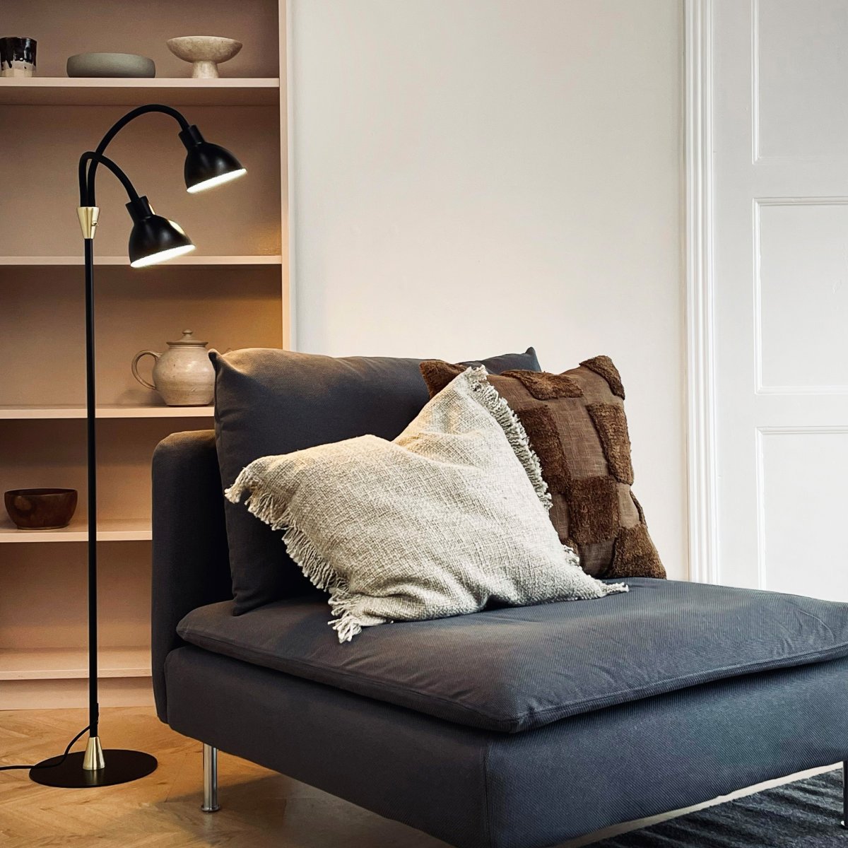 Lilje Svart golvlampa från Dyberg Larsen - Lily golvlampa i svart och m&auml;ssing kombinerar modern design med flexibilitet och funktionalitet.