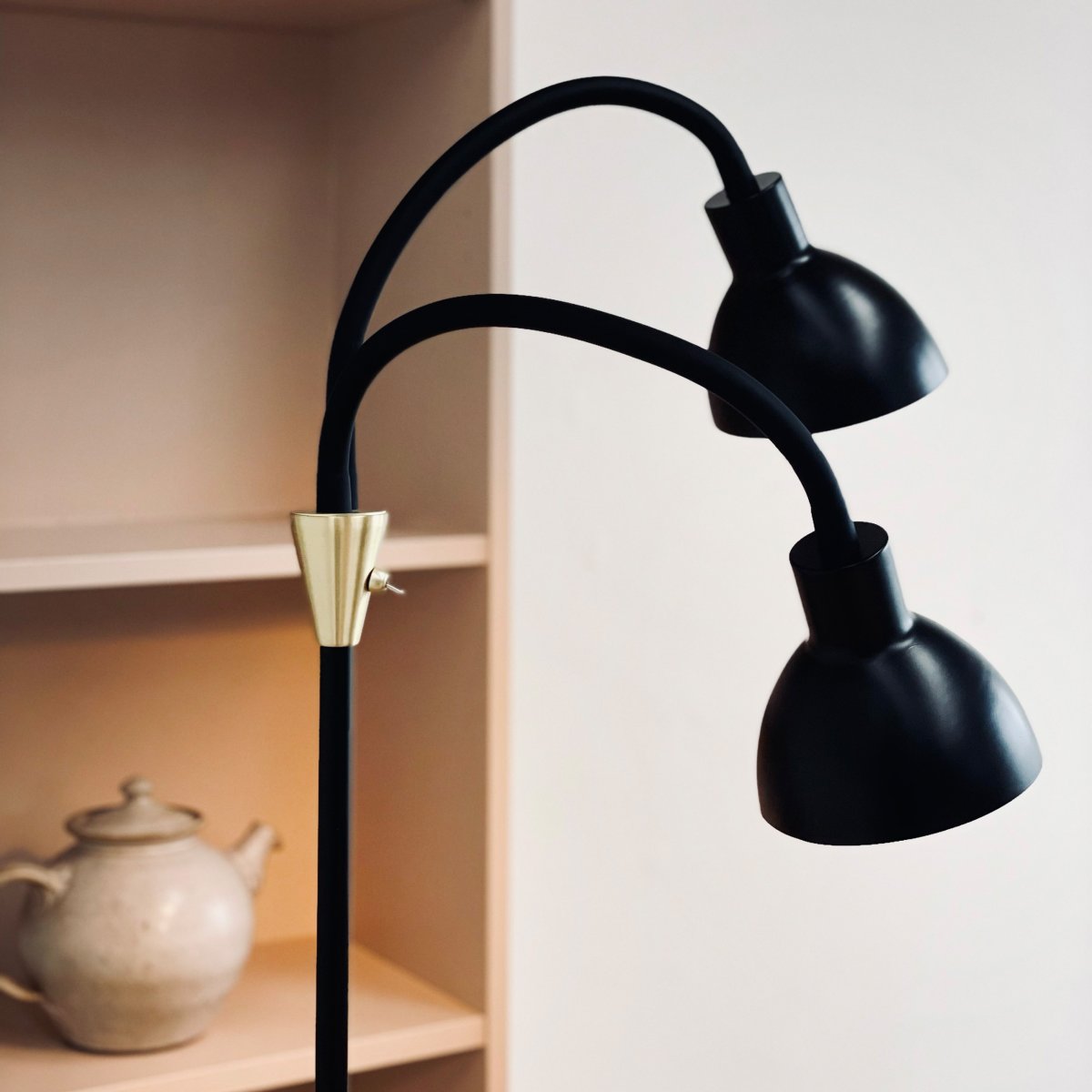 Lilje Svart golvlampa från Dyberg Larsen - Lily golvlampa i svart och m&auml;ssing kombinerar modern design med flexibilitet och funktionalitet.
