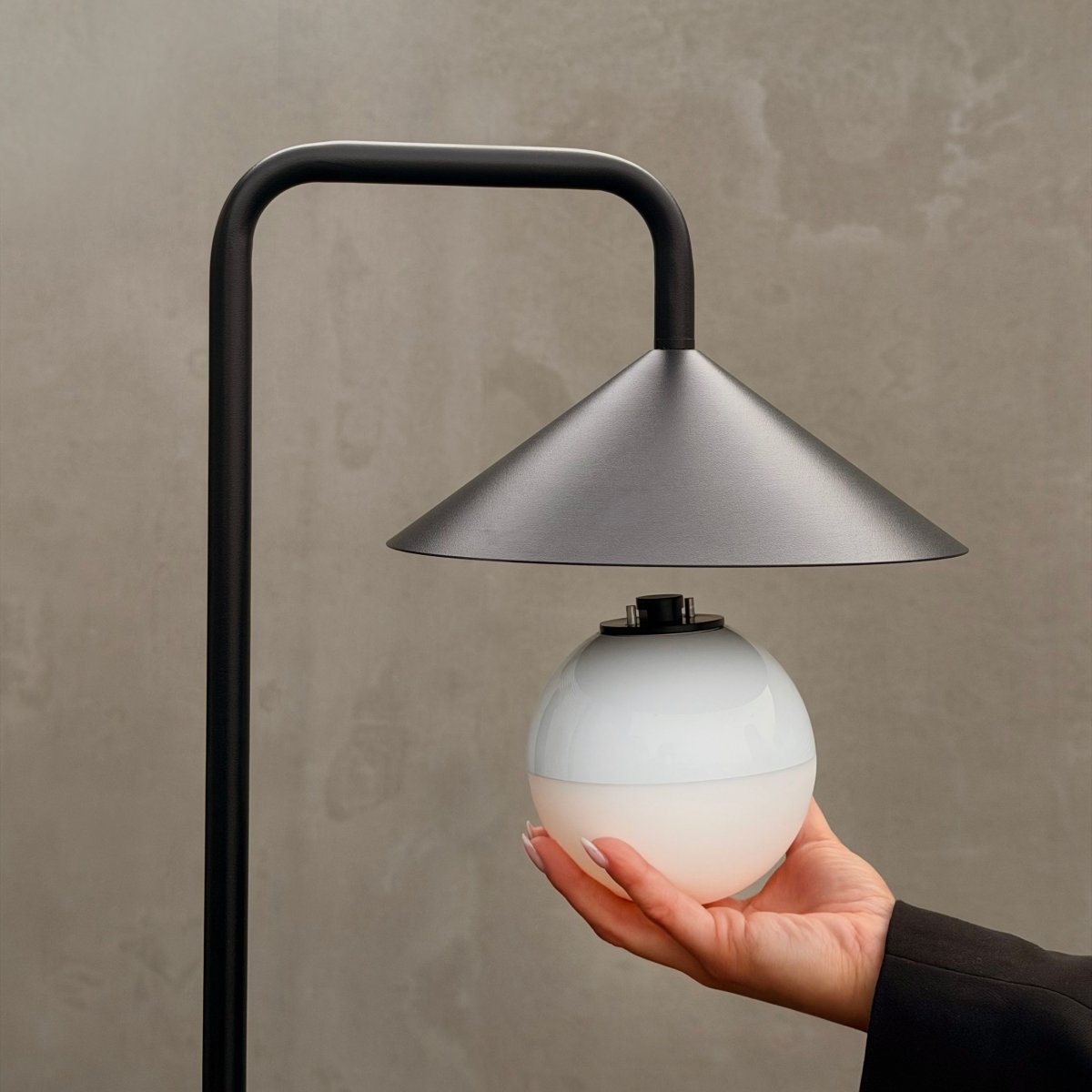 Nova 80cm Svart portabel från Dyberg Larsen - Lampan &auml;r tillverkad i robust metall och plast, med en vit rund kupa som sprider ett mjukt och mysigt sken.