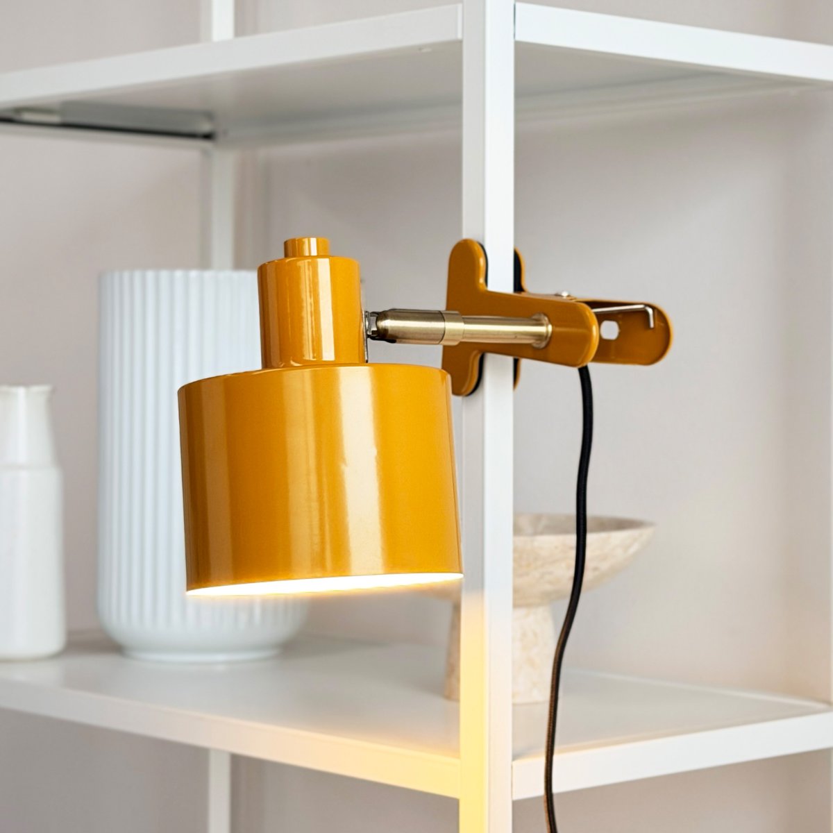 Ocean Gul klämlampa från Dyberg Larsen - Den kombinerar funktionalitet med ett modernt och enkelt formspr&aring;k som skapar ett lugnt och elegant uttryck.