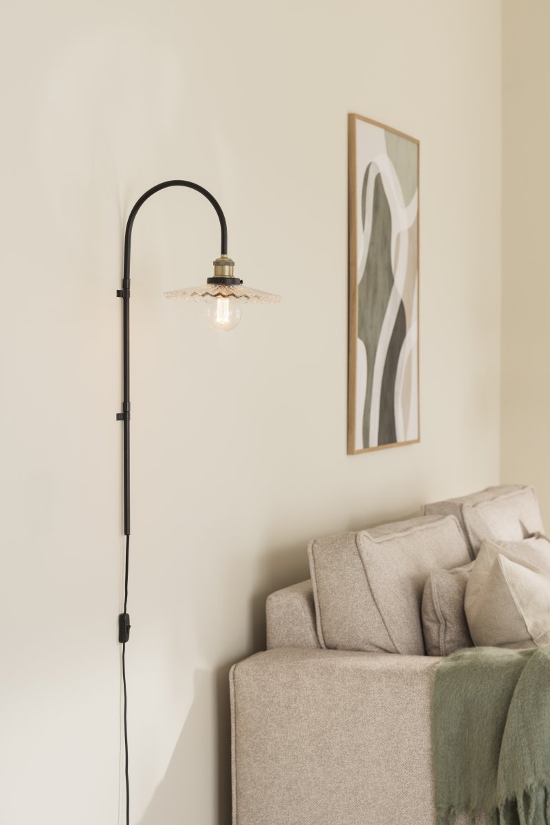 Cobbler 38cm Transparent/svart vägglampa från Globen Lighting - V&auml;ggf&auml;stet har tv&aring; stycken metallbyglar och medf&ouml;ljande skruvar f&ouml;r montering p&aring; v&auml;ggen och hela lampan &auml;r justerbar i sidled.
