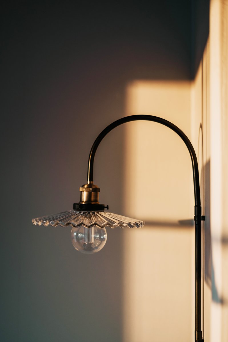 Cobbler 38cm Transparent/svart vägglampa från Globen Lighting - V&auml;ggf&auml;stet har tv&aring; stycken metallbyglar och medf&ouml;ljande skruvar f&ouml;r montering p&aring; v&auml;ggen och hela lampan &auml;r justerbar i sidled.