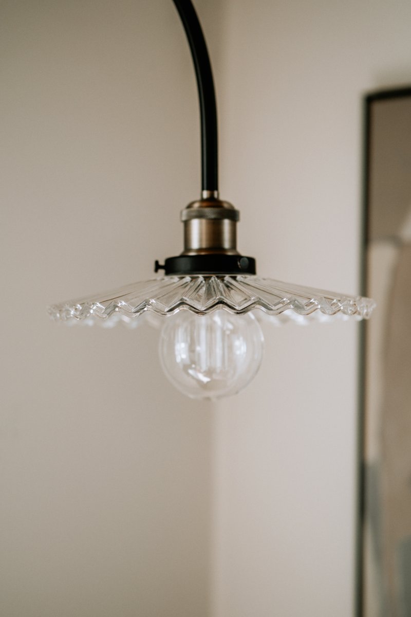 Cobbler 60cm Transparent/svart vägglampa från Globen Lighting - V&auml;ggf&auml;stet har tv&aring; stycken metallbyglar och medf&ouml;ljande skruvar f&ouml;r montering p&aring; v&auml;ggen och hela lampan &auml;r justerbar i sidled.