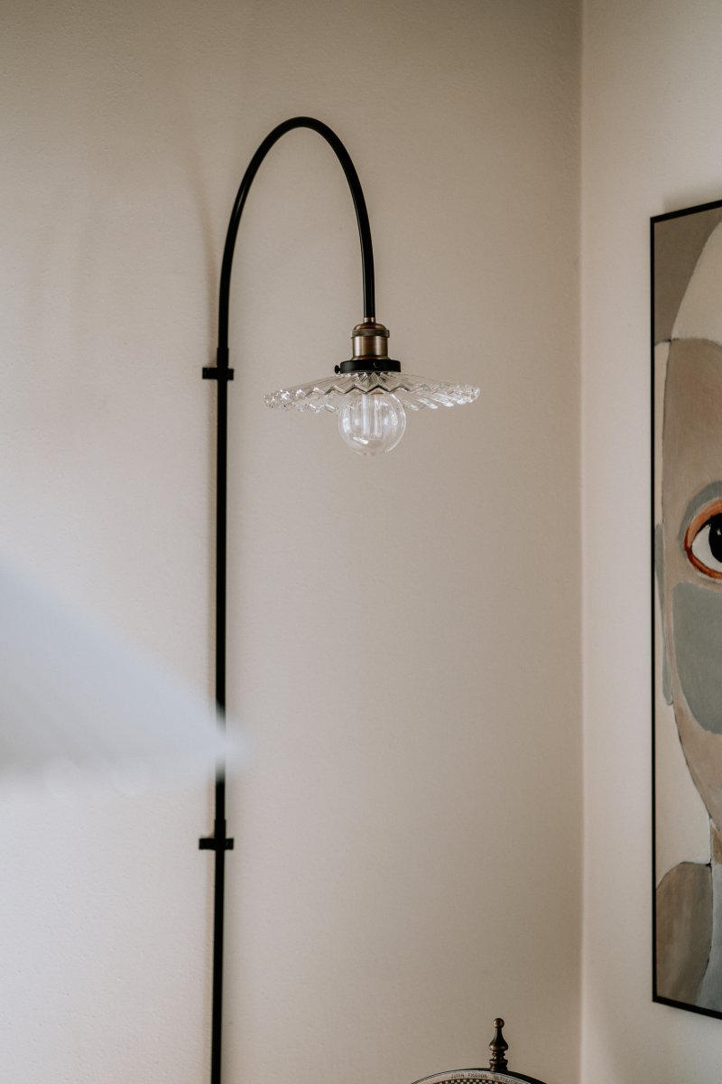 Cobbler 60cm Transparent/svart vägglampa från Globen Lighting - V&auml;ggf&auml;stet har tv&aring; stycken metallbyglar och medf&ouml;ljande skruvar f&ouml;r montering p&aring; v&auml;ggen och hela lampan &auml;r justerbar i sidled.