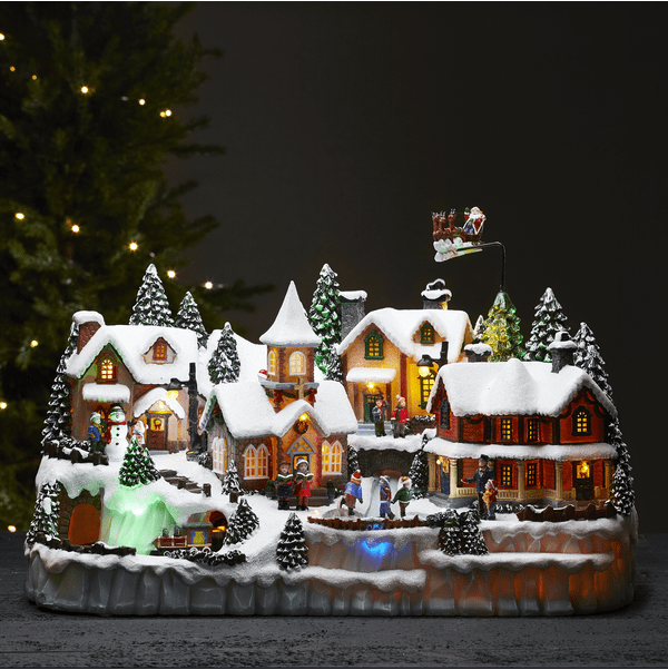 Largeville Flerfärgad från Star Trading - Stor och detaljrik juldekoration i form av en by med tre olika roterande delar; t&aring;gset, barn som &aring;kter skridskor och ren med sl&auml;de och tomte.
