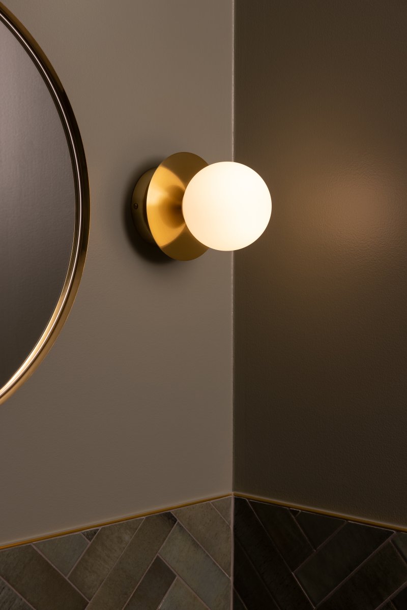 Art Deco Ø16 Borstad mässing/vit badrumslampa från Globen Lighting - Lampan &auml;r tillverkad av metall och har en vit glaskupa som skapar en fin ljusspridning i rummet.