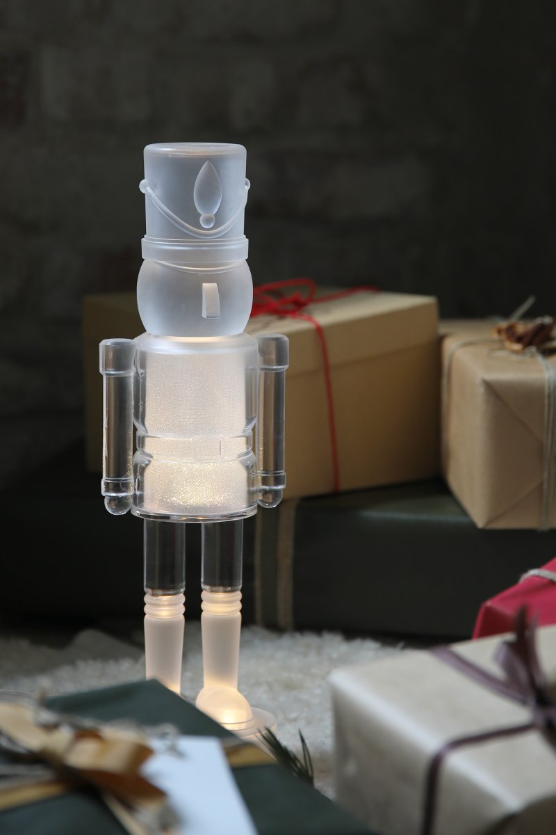 Douglas Transparent från Markslöjd - Formen av en n&ouml;tkn&auml;ppare med varmvitt ljus och dekorativt glitter.