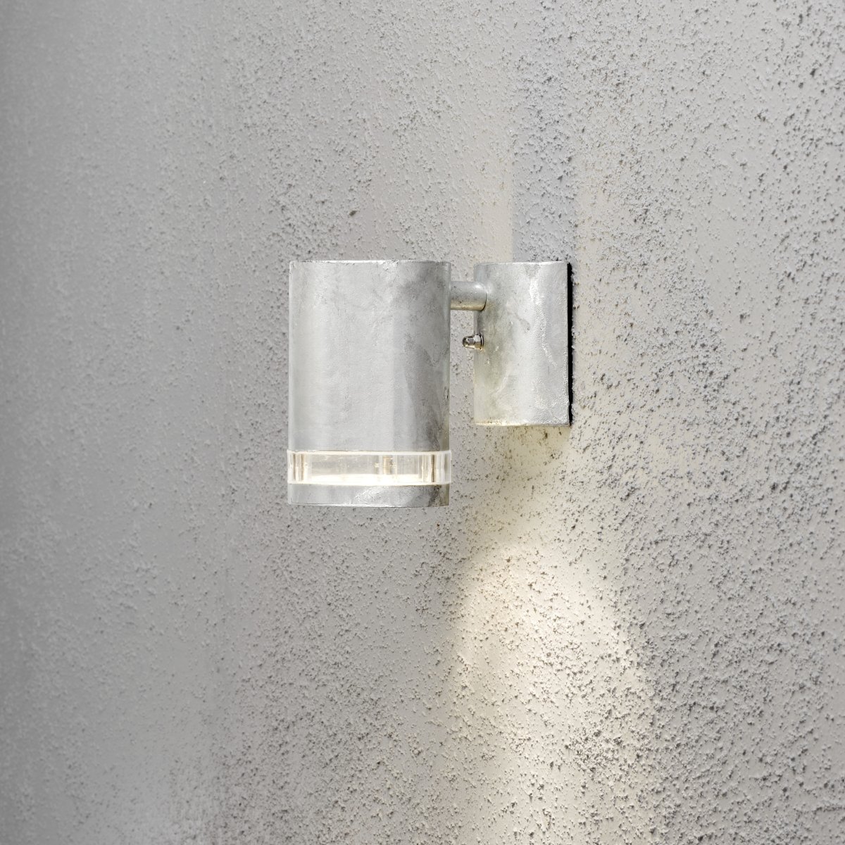 Modena Galvaniserad utelampa från Konstsmide - Modena &auml;r en stilren fasadlampa av galvaniserad pl&aring;t med en elegant detalj i transparent akrylglas som ger lampan ett modernt uttryck.