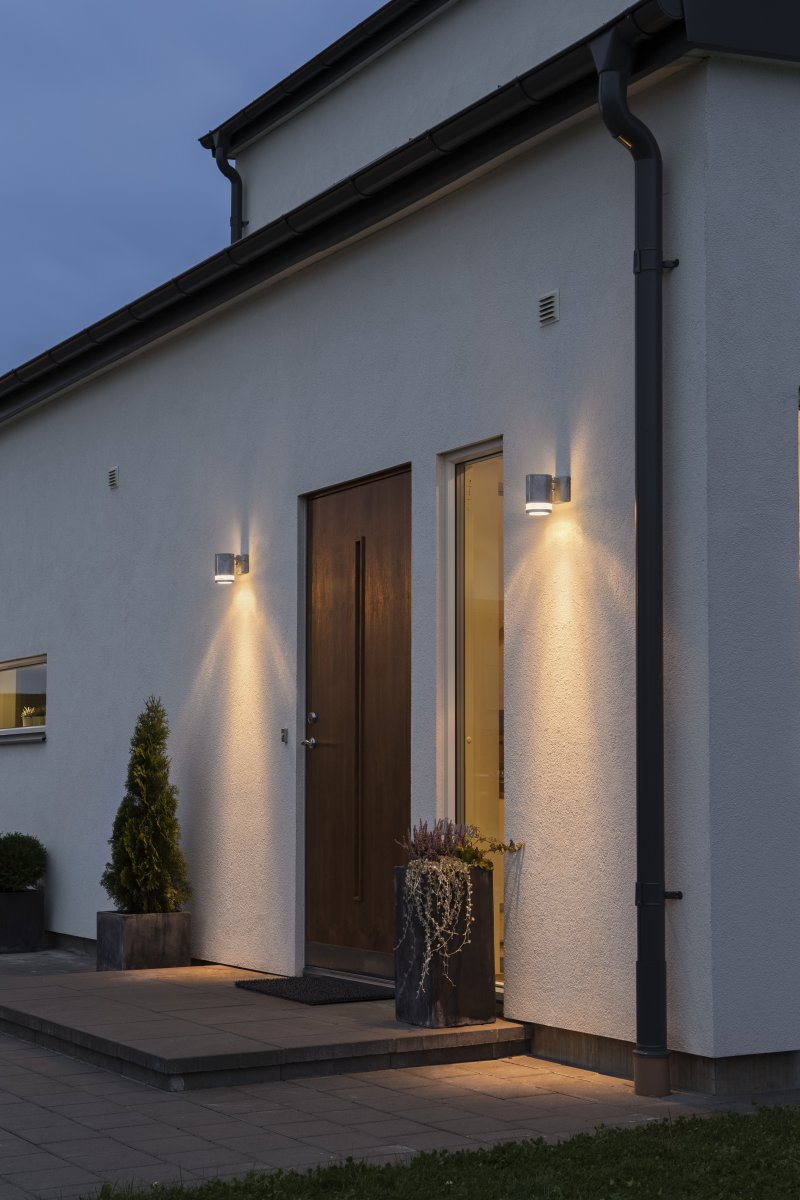 Modena Galvaniserad utelampa från Konstsmide - Modena &auml;r en stilren fasadlampa av galvaniserad pl&aring;t med en elegant detalj i transparent akrylglas som ger lampan ett modernt uttryck.