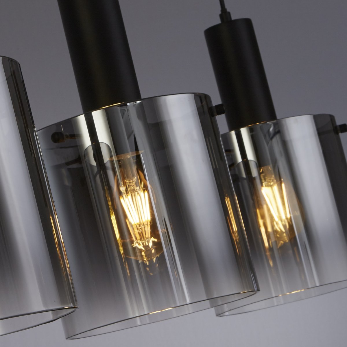 Sweden 100cm Svart taklampa från Searchlight - Sweden &auml;r en stilren taklampa med tre cylindriska kupor i svart, l&auml;tt r&ouml;kf&auml;rgat glas som ger ett sofistikerat och st&auml;mningsfullt ljus.