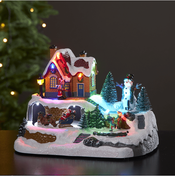 Winterville Flerfärgad från Star Trading - En h&auml;rlig juldekoraion med sn&ouml;gubben som ser ut over de skridsko &aring;kande barnen och tomten med sin sl&auml;de och renar.