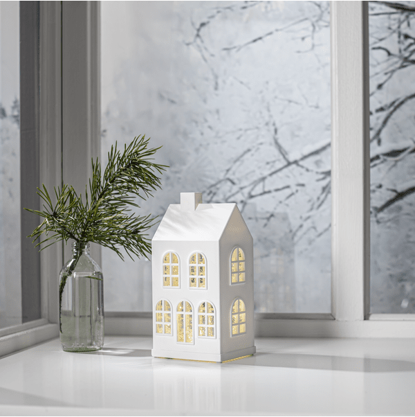 Vinter 22cm Vit från Star Trading - Det sn&ouml;ar och lyser vackert n&auml;r produkten &auml;r p&aring;slagen genom de glittrande f&ouml;nstrena med ett varmvitt sken.