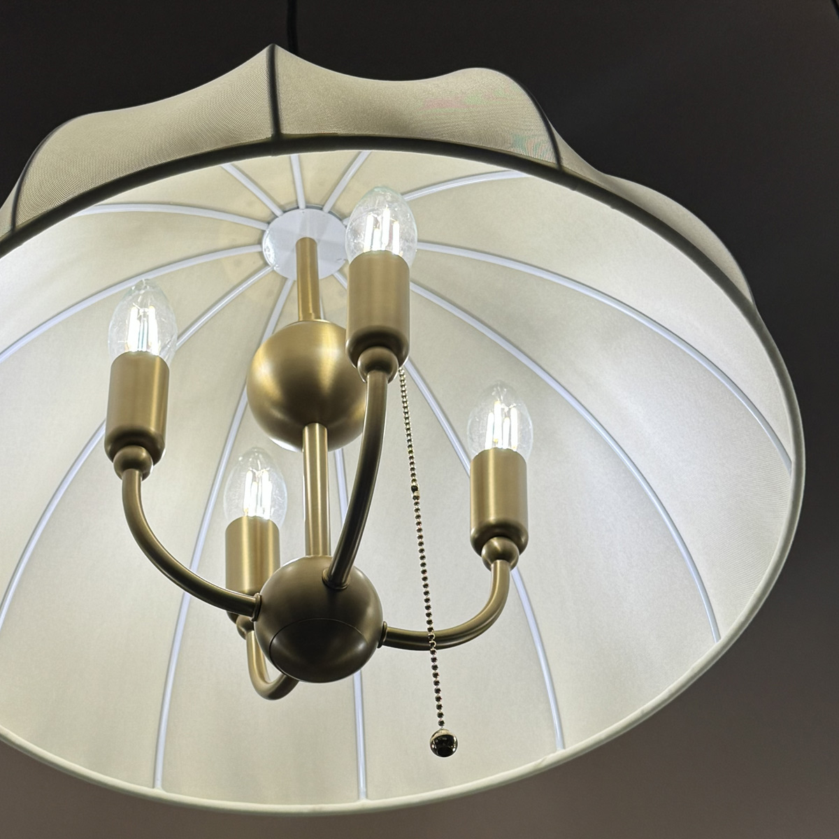 Crosby Ø45 Borstad guld taklampa från Elstead Lighting - Lampan &auml;r tillverkad i metall med borstad guldfinish och kombineras med en v&auml;lvd sk&auml;rm i tunt, ljust tyg som sl&auml;pper igenom ljuset fint.