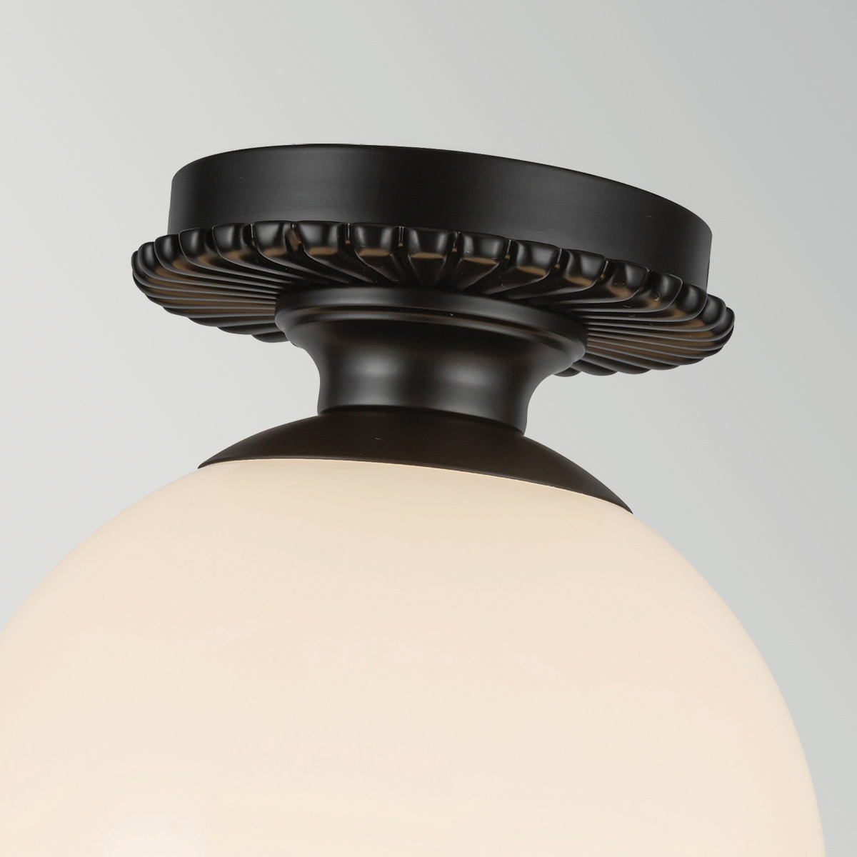 Otis Ø20 Svart badrumslampa från Elstead Lighting - Den runda kupan i blankt opalglas d&ouml;ljer ljusk&auml;llan och sprider ett mjukt och behagligt ljus i rummet.