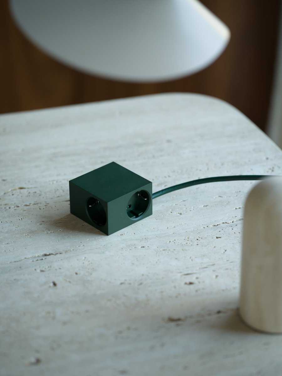 Cuboid Mörkgrön från Kord - Den f&ouml;renar estetik och funktion f&ouml;r m&auml;nniskor som uppskattar smart design i minsta detalj &ndash; till och med i ett grenuttag.