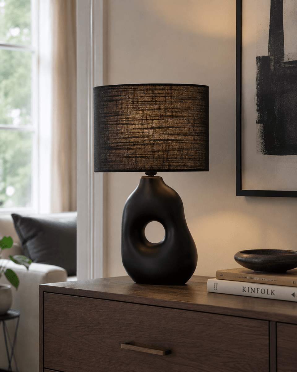 Pikazo 45cm Svart bordslampa från Lampan - Pikazo bordslampa i svart har en unik keramisk fot med skulptural form och ett dekorativt genomg&aring;ende h&aring;l, kompletterad med en matchande, oval linnesk&auml;rm.