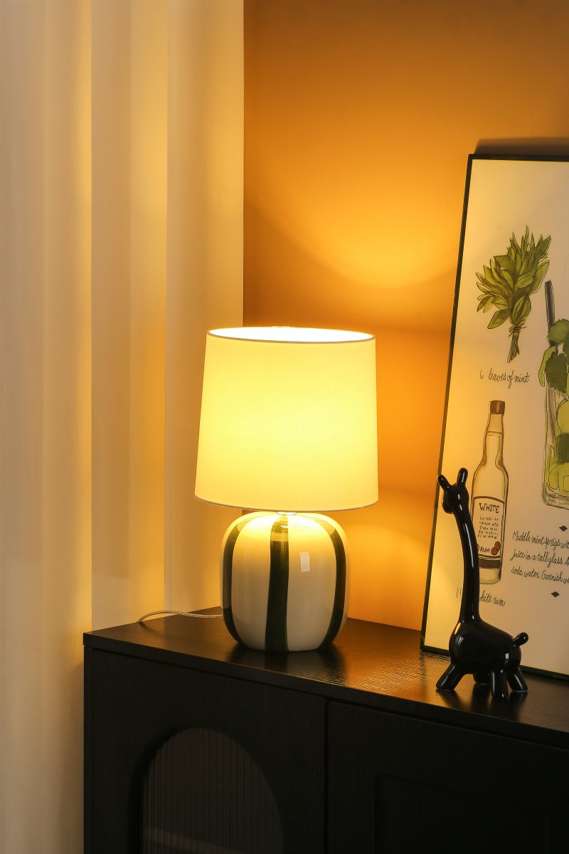 Pholca 38cm Vit/grön bordslampa från Nordic Lighting - Lampfoten &auml;r tillverkad i keramik med en kr&auml;mvit grund och gr&ouml;na r&auml;nder som skapar liv och karakt&auml;r.