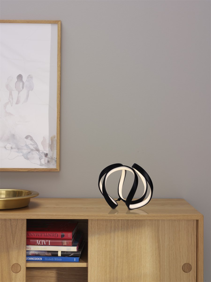 Wave 18cm Svart bordslampa från Cottex - Wave bordslampa i metall och silikon &auml;r en modern och elegant belysningsl&ouml;sning som ger ditt rum en unik och stilfull k&auml;nsla.