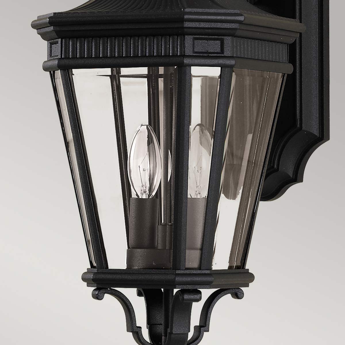 Cotswold Lane Svart utelampa från Elstead Lighting - Cotswold v&auml;gglampa har en klassisk design som p&aring;minner om antika gaslyktor, med detaljer som liknar arkitektoniska lister l&auml;ngst upp p&aring; varje ruta av fasetterat glas.