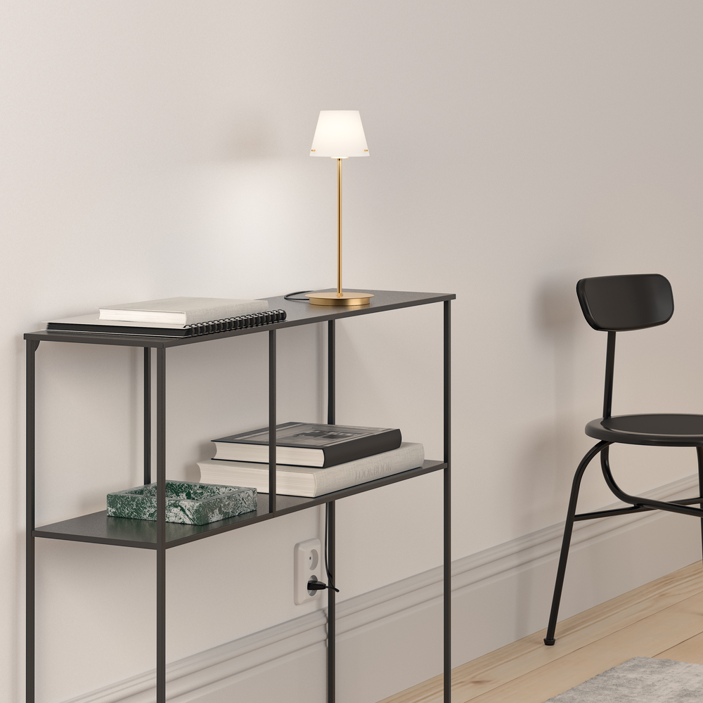 Gil 34cm Satin mässing bordslampa från Herstal - Den &auml;r tillverkad av metall med satin m&auml;ssingfinish och har en sk&auml;rm i vitt glas som sprider ett mjukt och behagligt ljus.