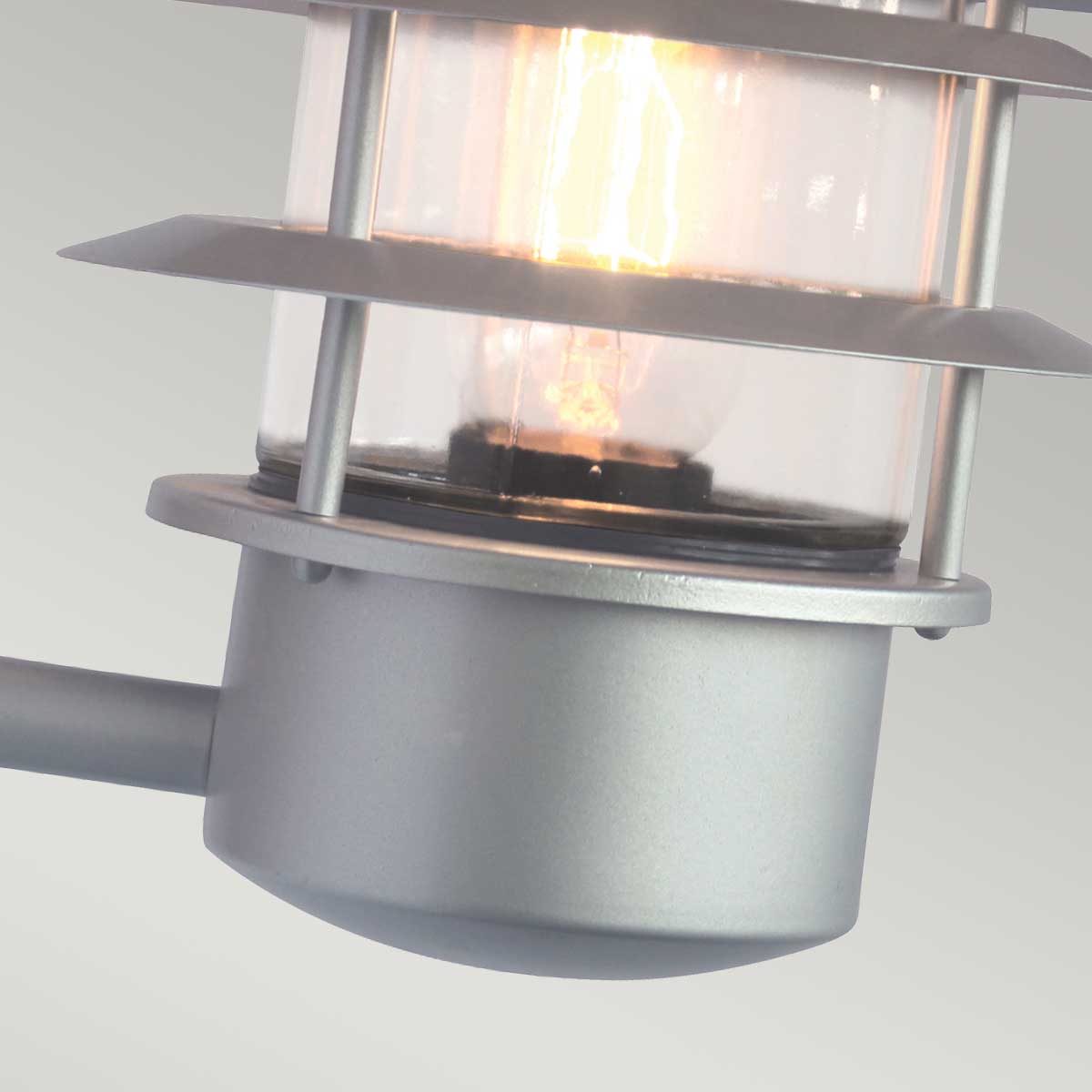 Helsingor PIR Ø22 Silver utelampa från Elstead Lighting - Tillverkad av rostfritt st&aring;l i silverfinish och glas, erbjuder den en robust och v&auml;derbest&auml;ndig konstruktion som &auml;r perfekt f&ouml;r fasader, entr&eacute;er och uteplatser.