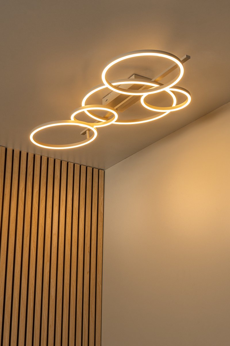 Nicola 132cm Beige plafond från Lucide - Lampan har integrerad LED d&auml;r f&auml;rgtemperaturen enkelt kan justeras mellan varmvitt och kallvitt ljus vid installation, vilket g&ouml;r den anpassningsbar f&ouml;r olika milj&ouml;er och behov.