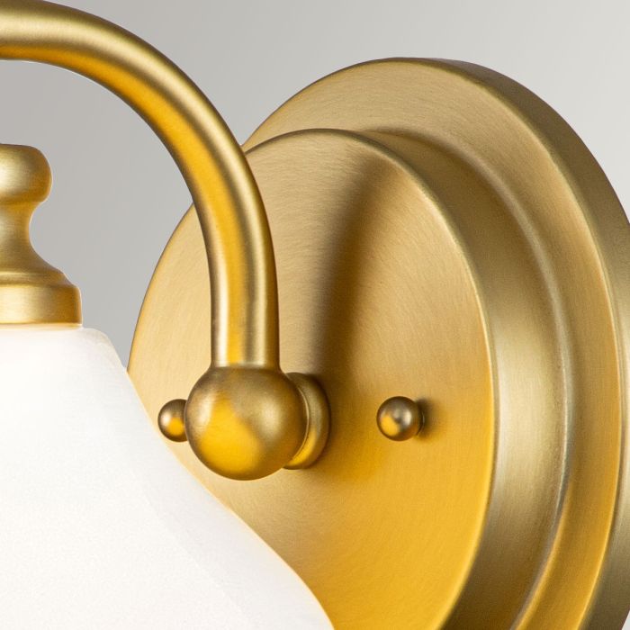 Ainsley Ø16 Borstad mässing badrumslampa från Elstead Lighting - Den kupformade sk&auml;rmen av opalglas ger ett mjukt och behagligt ljus och kombineras av en elegant borstad m&auml;ssingfinish som s&auml;tter pricken &ouml;ver i:et.