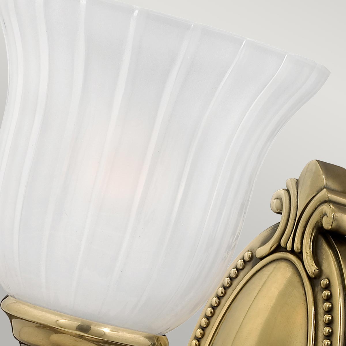 Francoise Ø15 Mässing badrumslampa från Elstead Lighting - Den har en vacker frostad glaskupa med r&auml;fflad design som sprider ett mjukt ljus, och den dekorativa m&auml;ssingsfoten ger en stilfull touch.