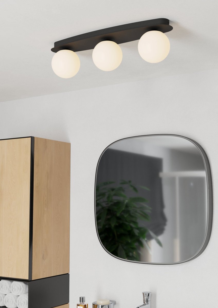 Castrovido 58cm Svart badrumslampa från Eglo - Den &auml;r tillverkad i svart metall och har tre runda kupor i opalglas som sprider ett mjukt och j&auml;mnt ljus.