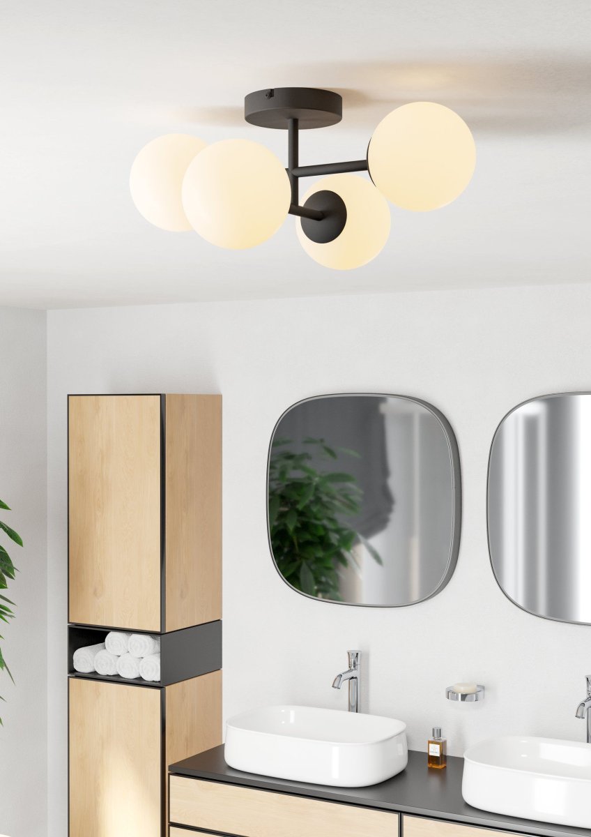 Castrivido 48cm Svart badrumslampa från Eglo - Den &auml;r tillverkad i svart metall och har fyra runda kupor i opalglas som sprider ett mjukt och j&auml;mnt ljus.