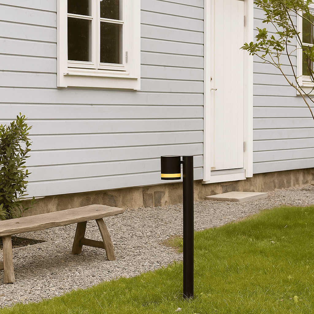 Karlshamn 80cm Svart pollare från Nordic Lighting - Lampan sprider ett mjukt ljus ned&aring;t samtidigt som ljuset &auml;ven fl&ouml;dar genom springan och skapar ett subtilt rundstr&aring;lande sken.