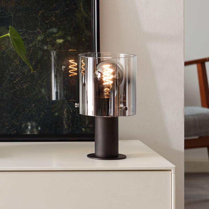 Beth 26cm Rökfärgad bordslampa från Brilliant - Den fungerar lika bra som dekorativ detalj som f&ouml;r att ge ljus &aring;t m&ouml;rka h&ouml;rn och bidrar till en trivsam atmosf&auml;r i hemmet.