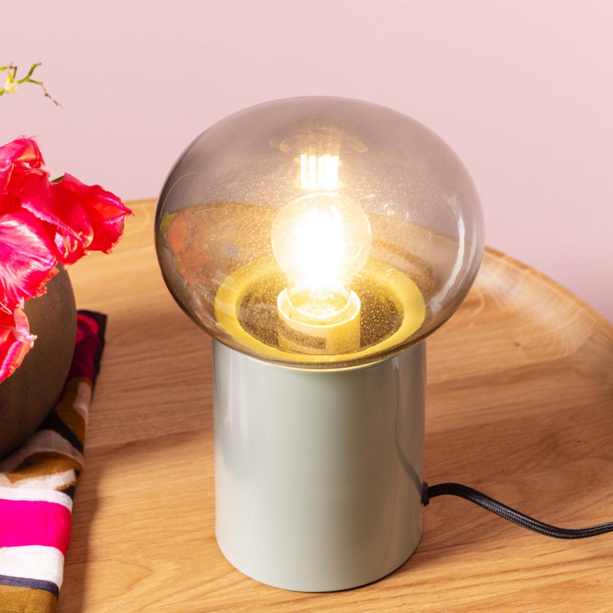 Knut 22cm Grön bordslampa från Brilliant - Den gr&ouml;na lampfoten ger ett fr&auml;scht och levande uttryck, medan den r&ouml;ktonade glaskupan skapar en mjuk och st&auml;mningsfull ljusspridning.