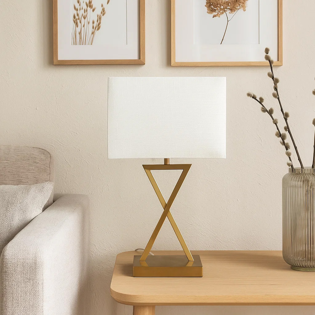 X-factor 54cm Mässing bordslampa från Nordic Lighting - X-factor bordslampa kombinerar en modern geometrisk metallfot i elegant m&auml;ssingsfinish med en vit linnesk&auml;rm.